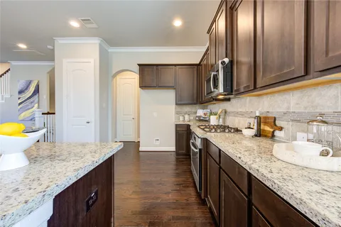 a kitchen with granite countertop stainless steel appliances and wooden cabinets
