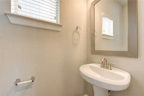 a bathroom with a sink a mirror and a window