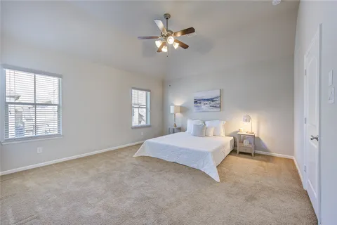 a spacious bedroom with a large bed chandelier and a window