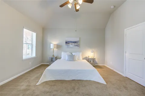 a spacious bedroom with a bed and a chandelier