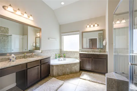 a bathroom with a sink vanity tub and a mirror