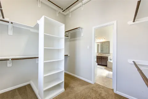 a view of walk in closet with empty racks