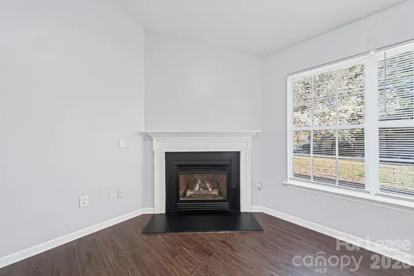 a living room with a fireplace and a floor to ceiling window
