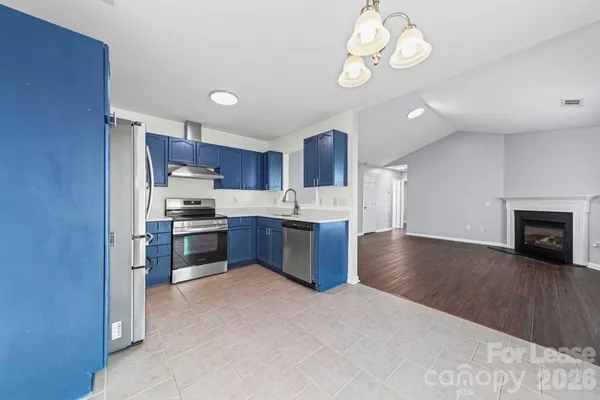 a kitchen with stainless steel appliances a refrigerator a stove microwave and a sink with wooden floor