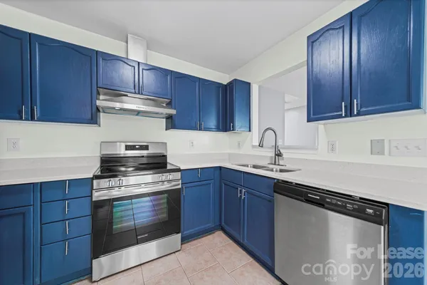 a kitchen with stainless steel appliances granite countertop wooden cabinets stove top oven and sink