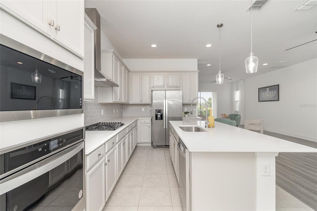 15701 Vetta Drive Montverde, FL 34756 - Photo 21 of 68 a kitchen with a sink a stove and chairs