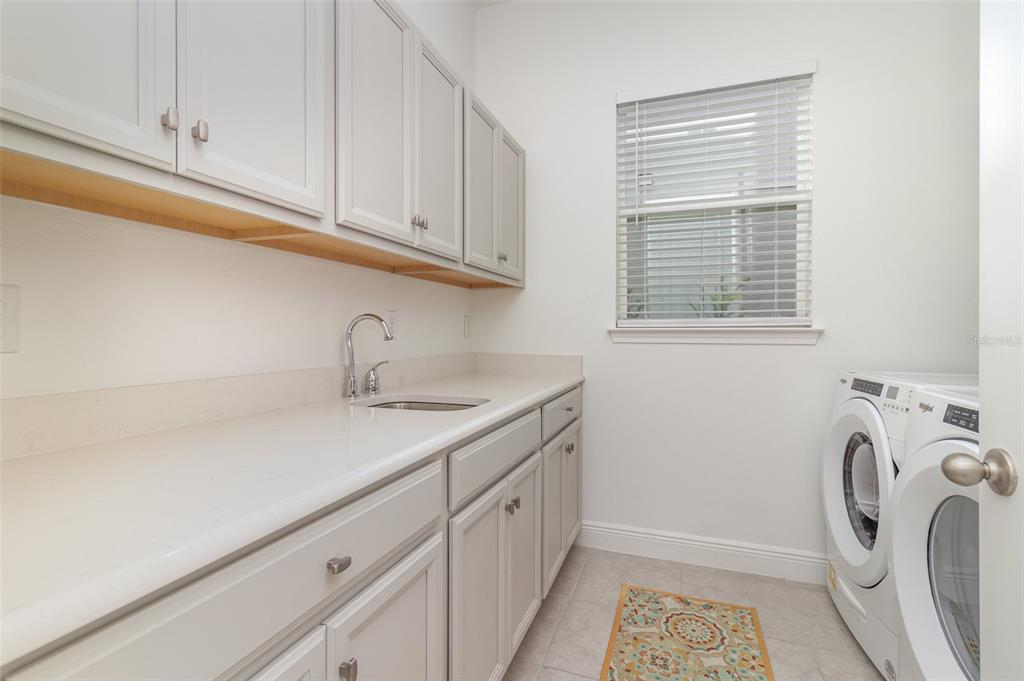 15701 Vetta Drive Montverde, FL 34756 - Photo 26 of 68 a utility room with a sink a washer and dryer