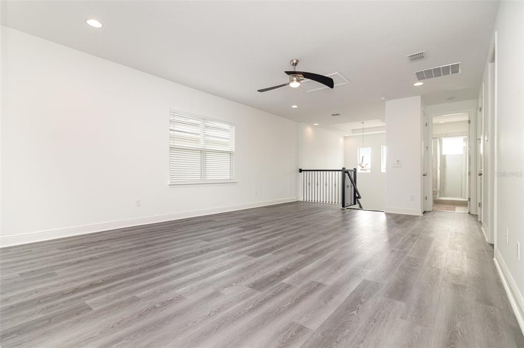 15701 Vetta Drive Montverde, FL 34756 - Photo 32 of 68 an empty room with wooden floor and windows