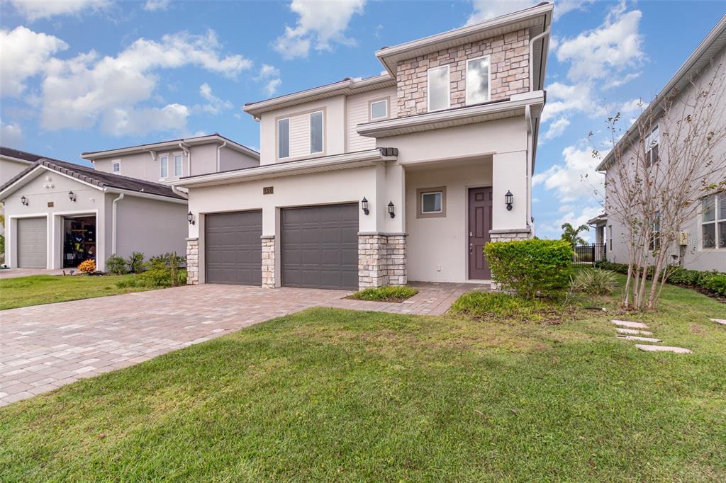 15701 Vetta Drive Montverde, FL 34756 - Photo 64 of 68 a front view of a house with a yard and garage