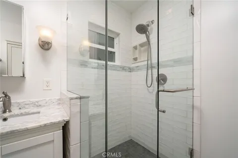 a bathroom with a granite countertop shower sink and mirror