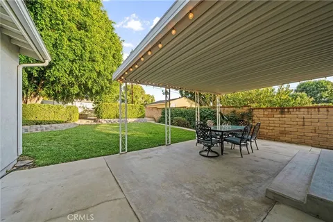 a view of park with table and chairs under an umbrella