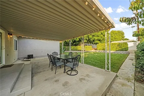 a view of patio with table and chairs and potted plants