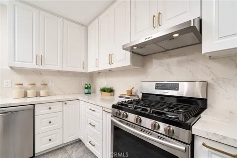 a kitchen with white cabinets and appliances
