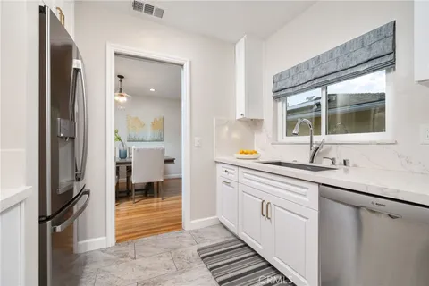 a kitchen with stainless steel appliances granite countertop a refrigerator and a sink