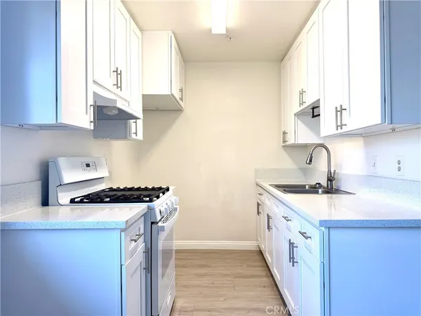 a kitchen with stainless steel appliances a sink stove and cabinets