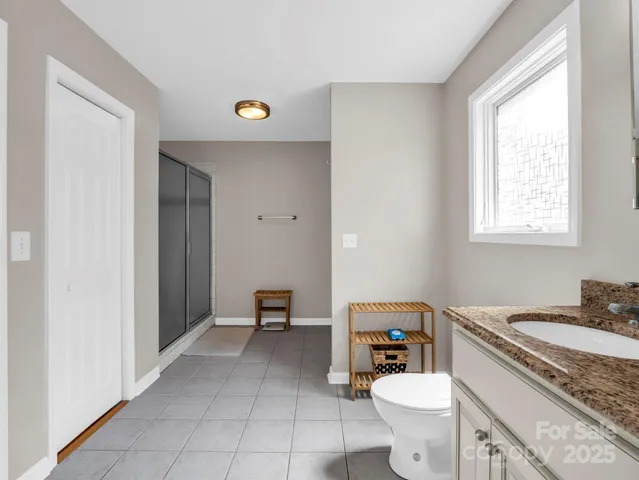 a bathroom with a granite countertop toilet sink and mirror