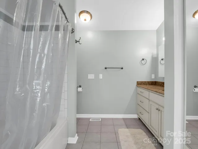 a bathroom with a granite countertop sink a toilet and shower