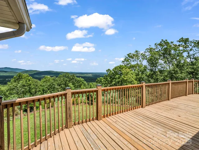 a view of balcony with wooden floor and fence