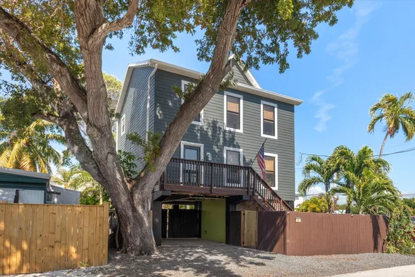 a front view of a house with a tree