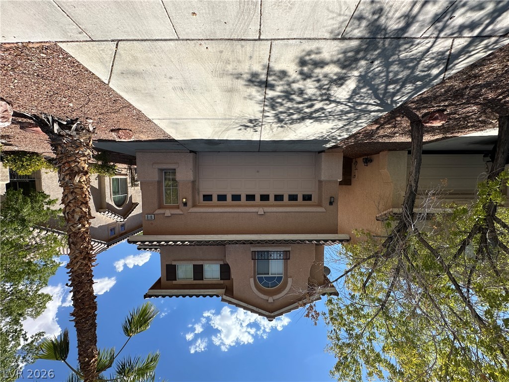 A welcoming façade with an attached garage and desert landscaping invites comfortable living.