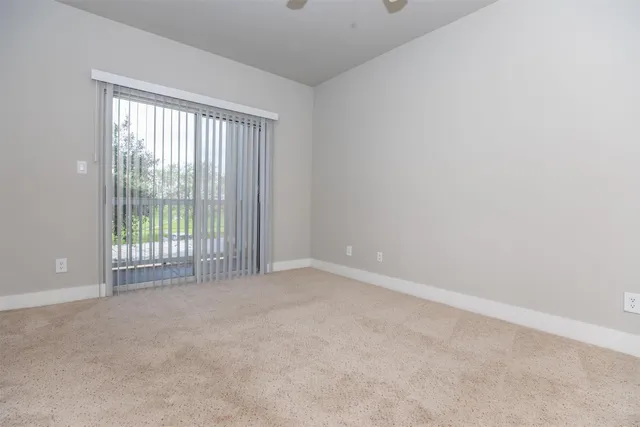 a view of an empty room and chandelier fan