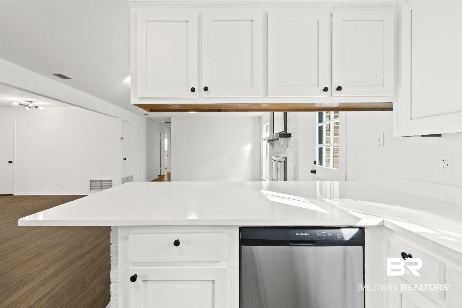 3270 Graham Road North Mobile, AL 36618 - Photo 21 of 54 Kitchen featuring dark wood-type flooring, white cabinetry, dishwasher, and kitchen peninsula