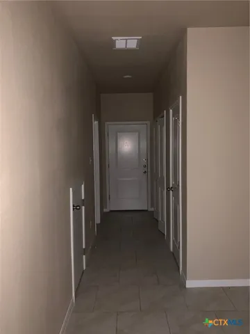 a view of a hallway with wooden shelves