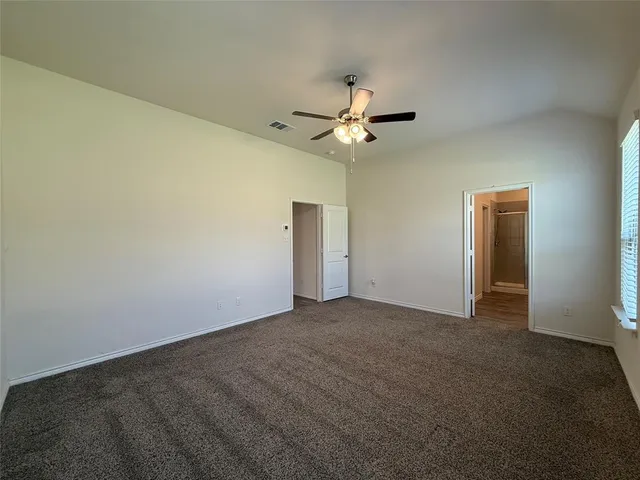 an empty room with a ceiling fan and a fan