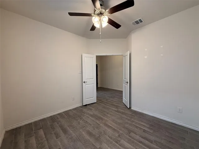 an empty room with a ceiling fan and fan