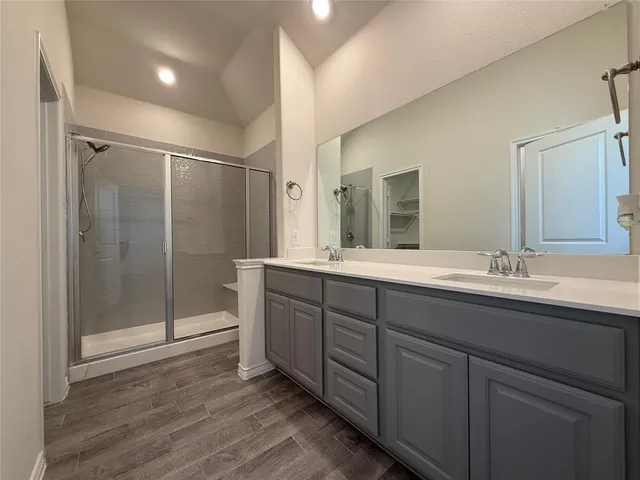 a bathroom with a sink a toilet a mirror and shower