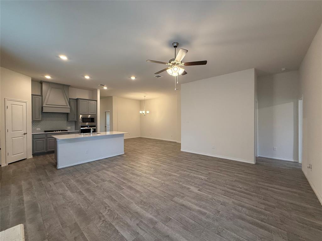 4124 Ellinger Drive Forney, TX 75126 - Photo 6 of 28 a large kitchen with stainless steel appliances kitchen island a large counter top and a stove