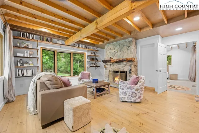 a living room with furniture large window and a fireplace