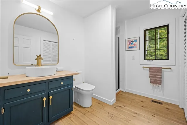 a bathroom with a granite countertop toilet a sink and a mirror