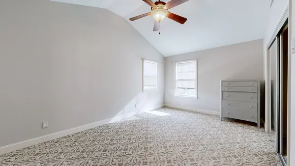 a bedroom with a bed a window and a chandelier
