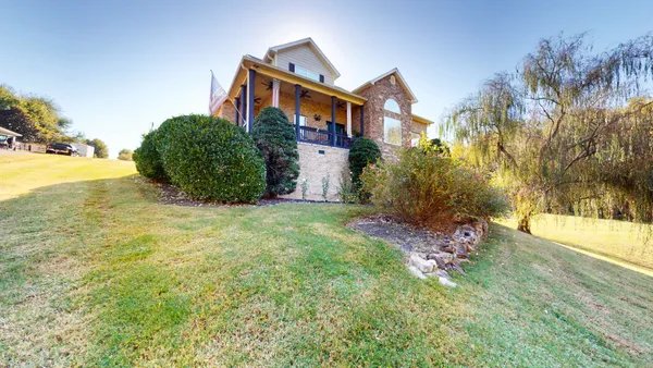 a view of a house with porch and garden