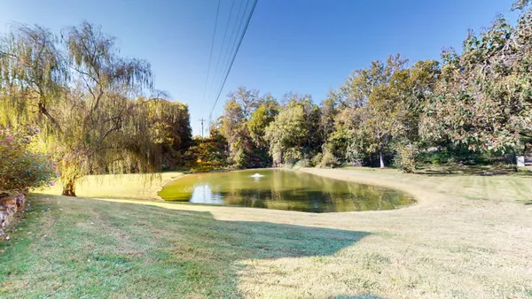 a view of a house with backyard and sitting area