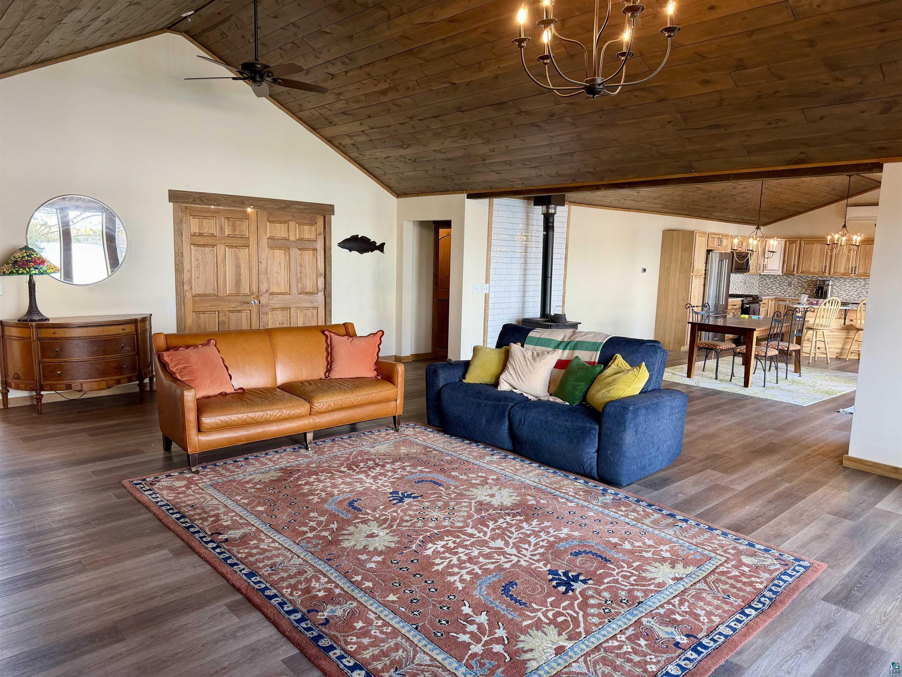 5274 Marble Lake Road Two Harbors, MN 55616 - Photo 10 of 79 Expansive living area with wood-finish flooring, vaulted wood plank ceiling, and a prominent wood-burning stove