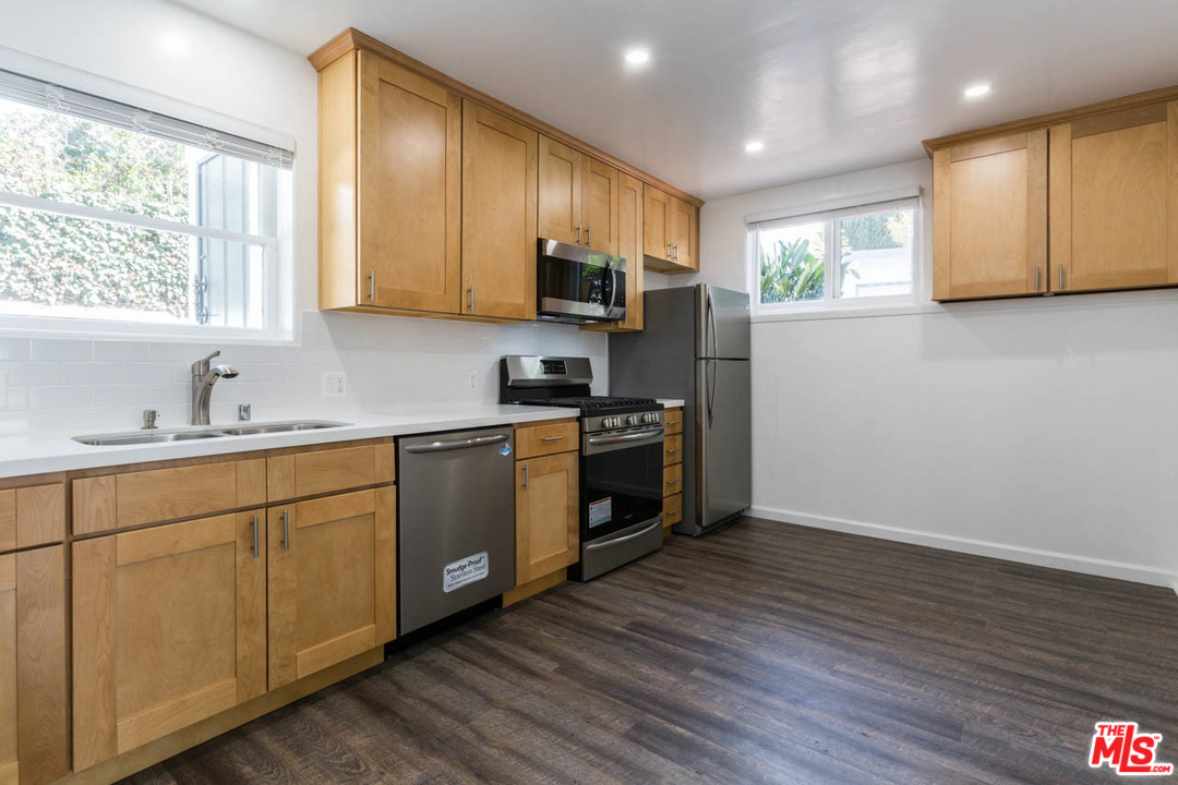 1212 Scenic Drive Glendale, CA 91205 - Photo 9 of 42 a kitchen with stainless steel appliances granite countertop a sink a stove a refrigerator with grey cabinets and wooden floor