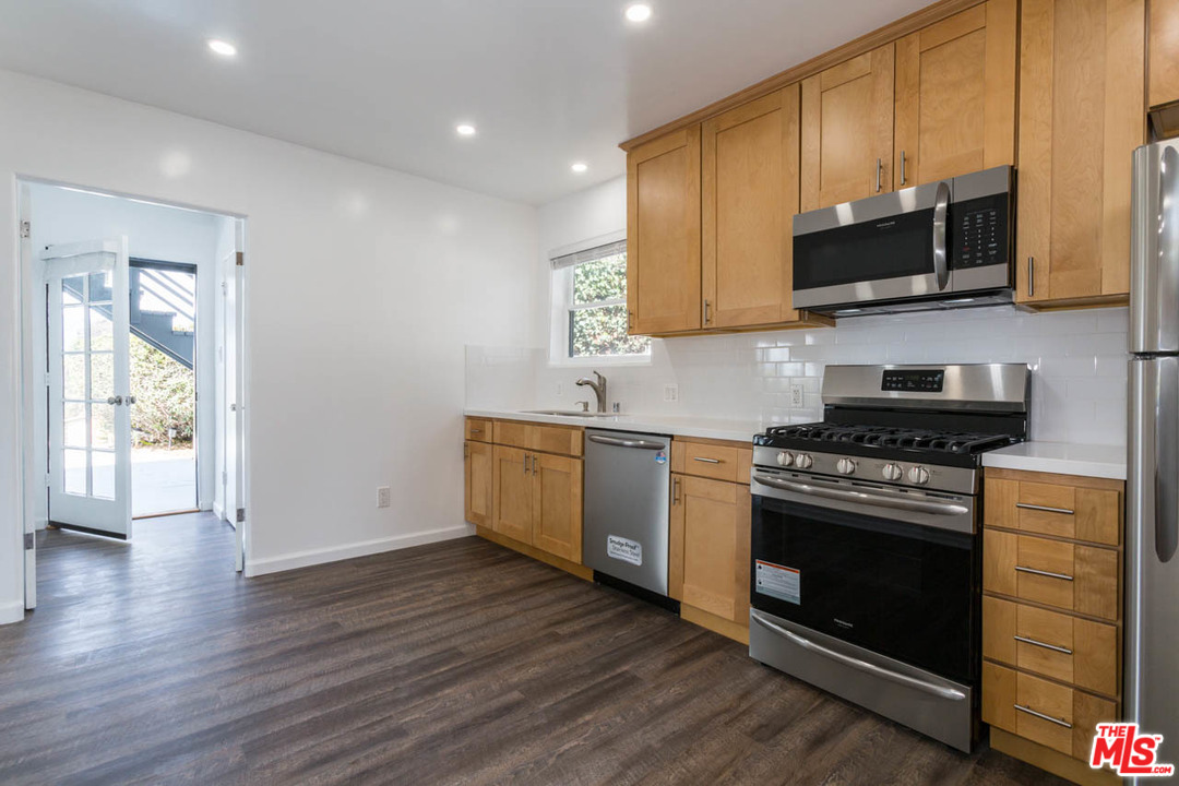 1212 Scenic Drive Glendale, CA 91205 - Photo 10 of 42 a kitchen with stainless steel appliances a stove a microwave oven cabinets and a wooden floor