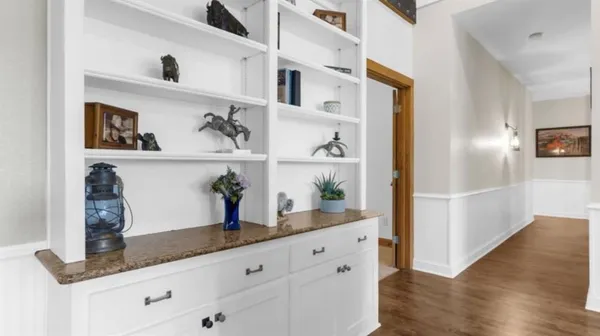 a kitchen with stainless steel appliances granite countertop a refrigerator and wooden floor