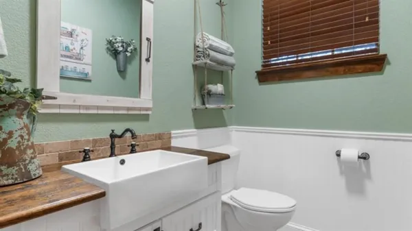 a bathroom with a sink a toilet and mirror