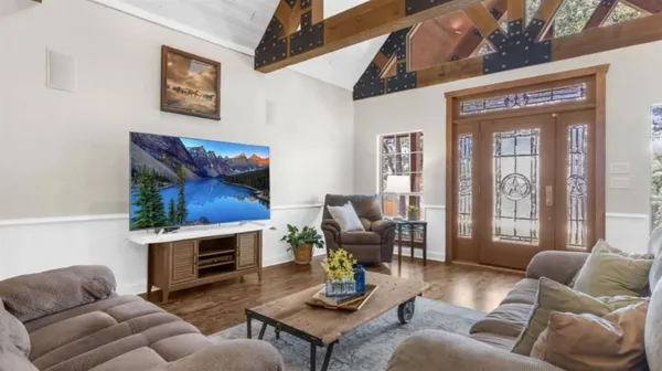 a living room with furniture fireplace and a large window