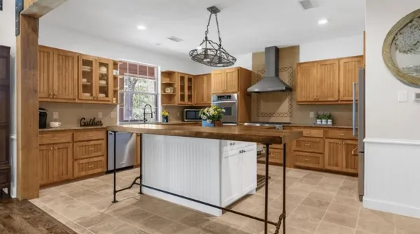 a kitchen with stainless steel appliances granite countertop a stove a sink and a refrigerator