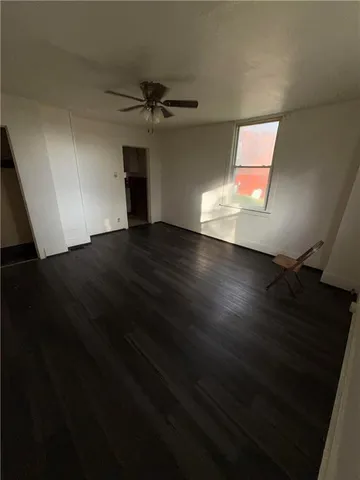 a view of a livingroom with a ceiling fan and wooden floor