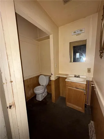 a bathroom with a toilet sink and mirror