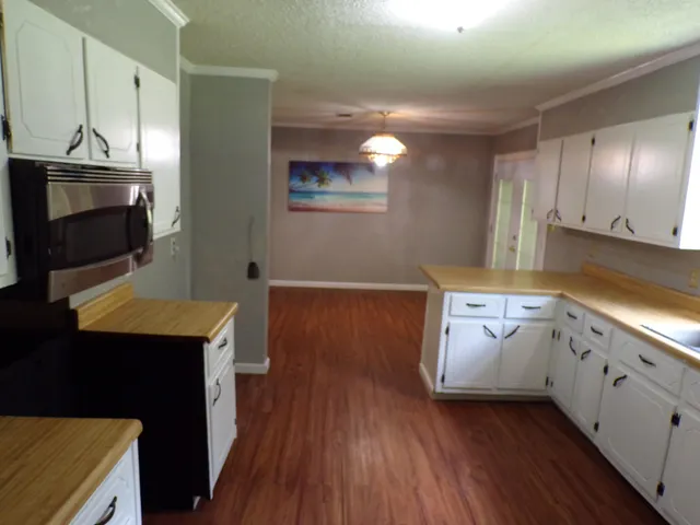 a kitchen with granite countertop a stove a sink and a microwave