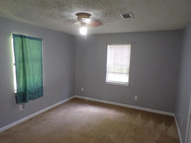 an empty room with windows and closet