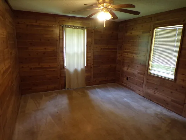 en empty room with windows and brick walls