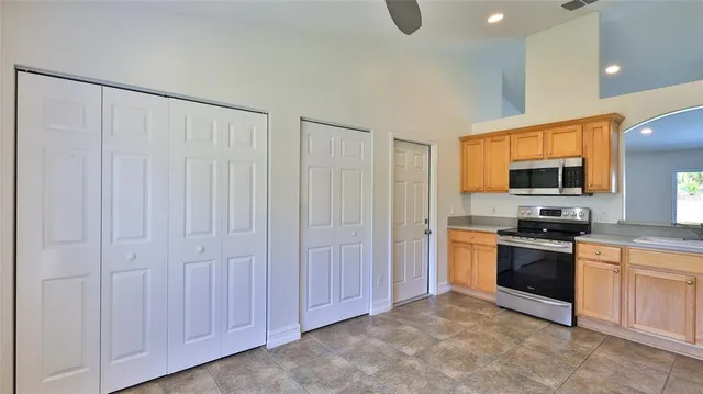 a large kitchen with cabinets stainless steel appliances and a window