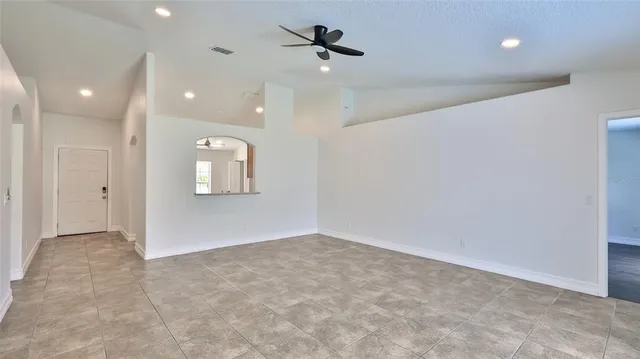 an empty room with fan and windows